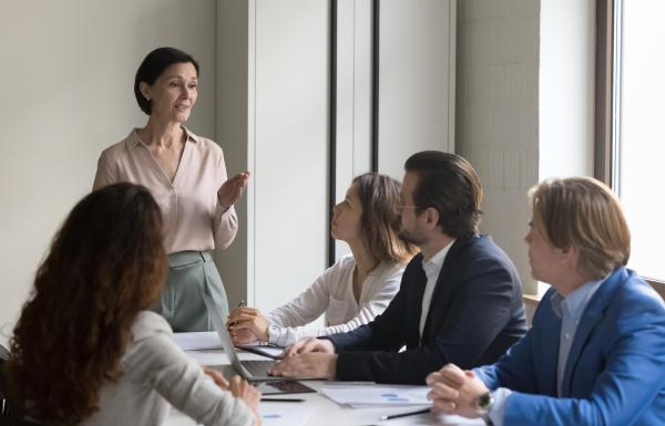 Woman speaking to team of professionals