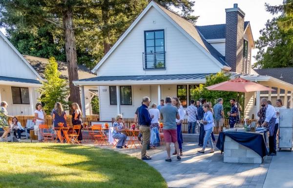People socializing outside neighborhood cottages