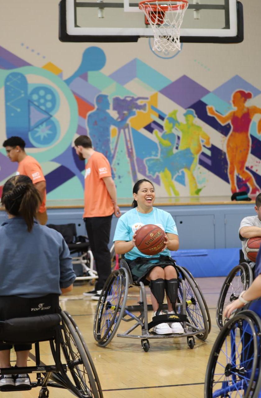Individuals in wheelchairs play basketball