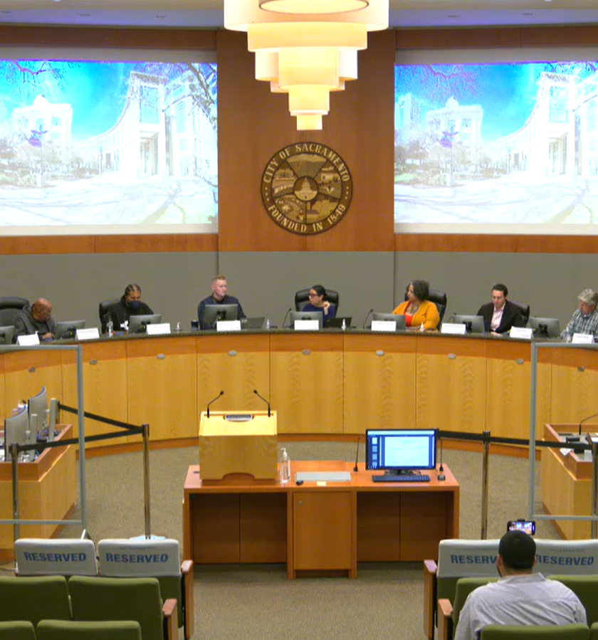 A group of commission members sitting at a long dais.