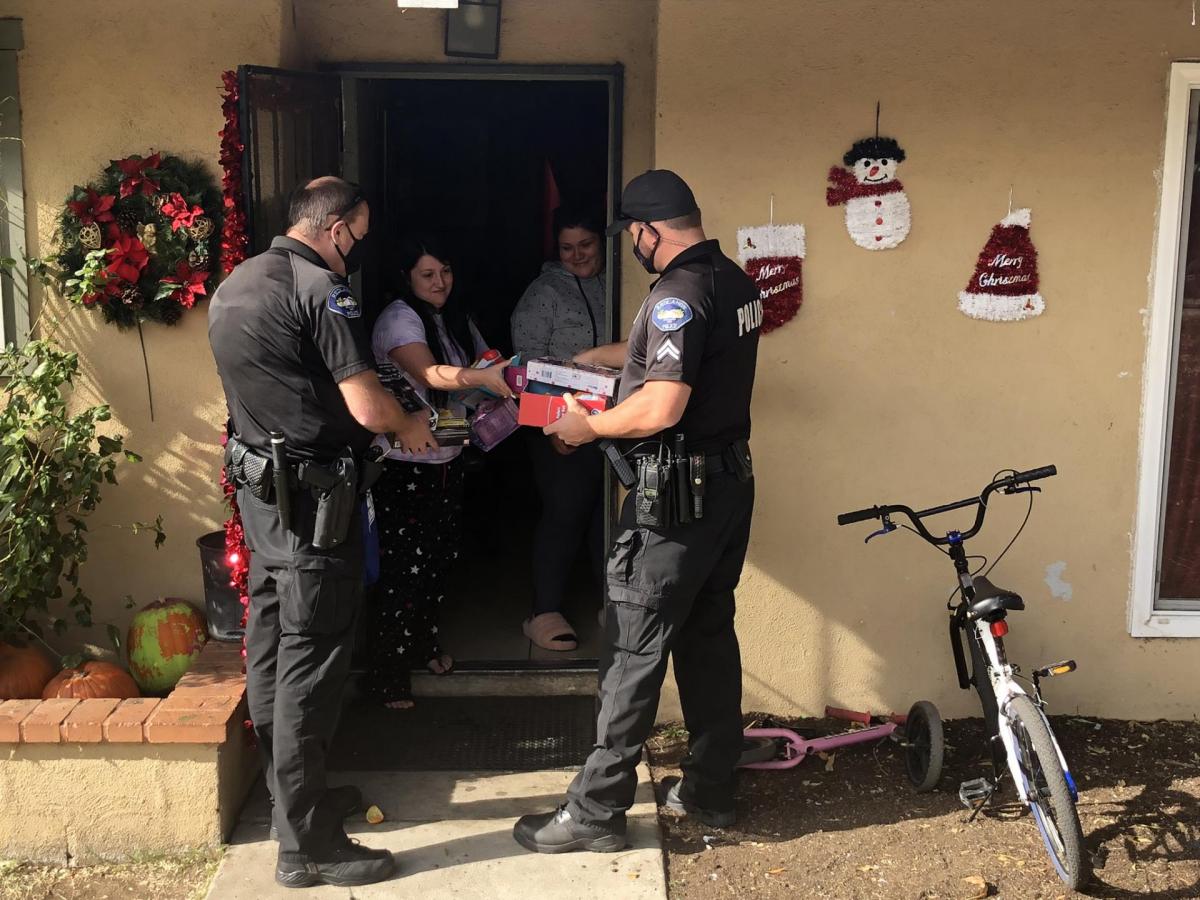 Redlands police officers deliver gifts to children in the community during the holidays.