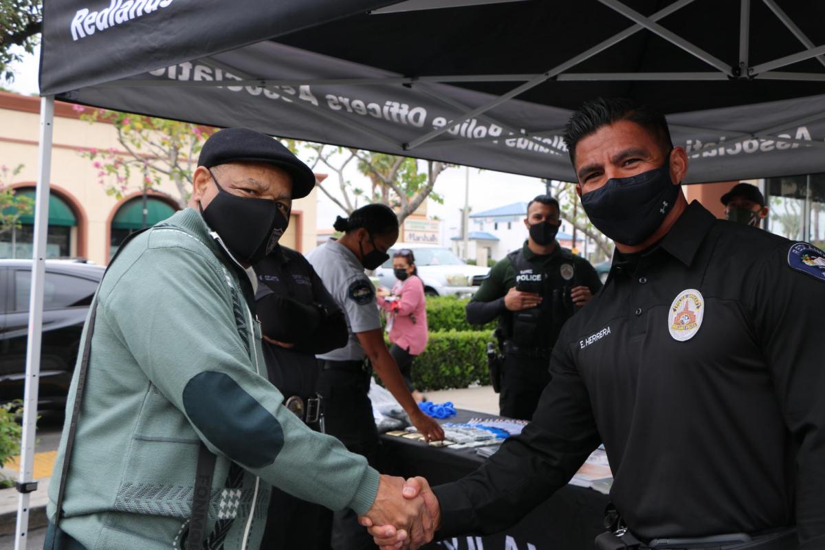 A Redlands Police Officer connects with a resident at a community policing event.