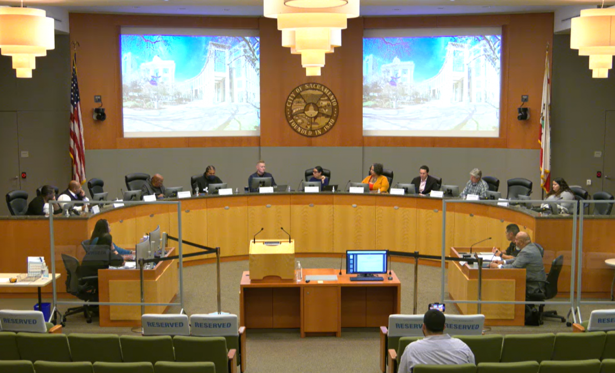 A group of commission members sitting at a long dais.