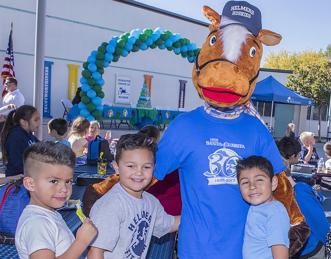 Santa Clarita mascot, Sammy Clarita, poses with children at a local event. 