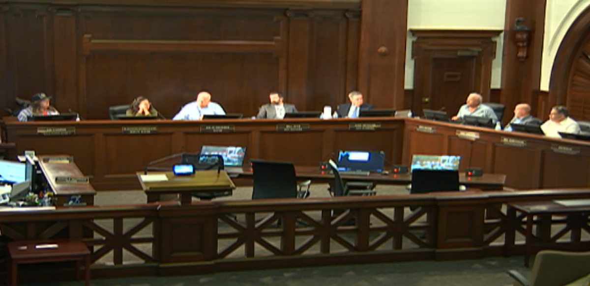 Council members seated at a dais for a city council meeting.