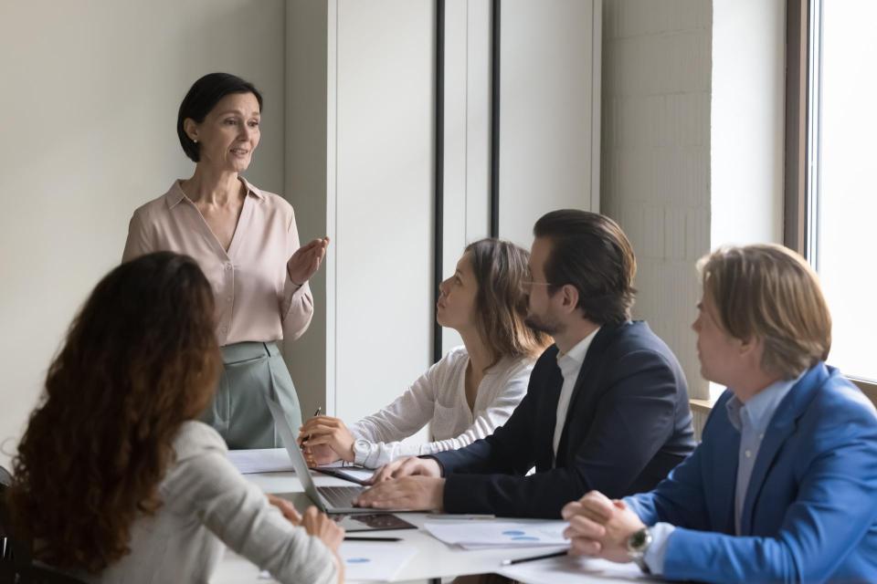 Woman speaking to team of professionals