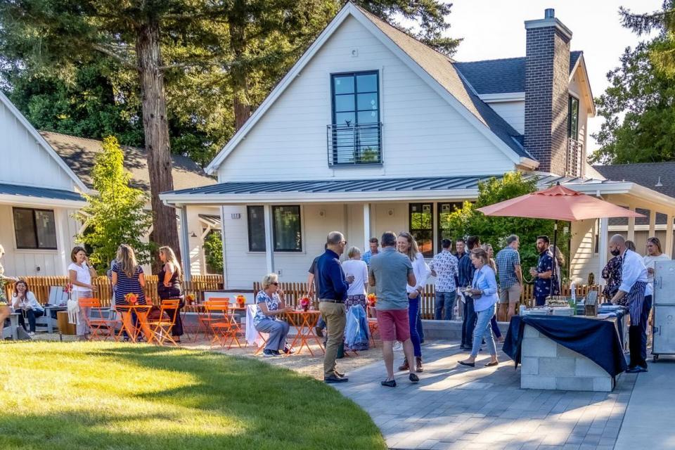 People socializing outside neighborhood cottages