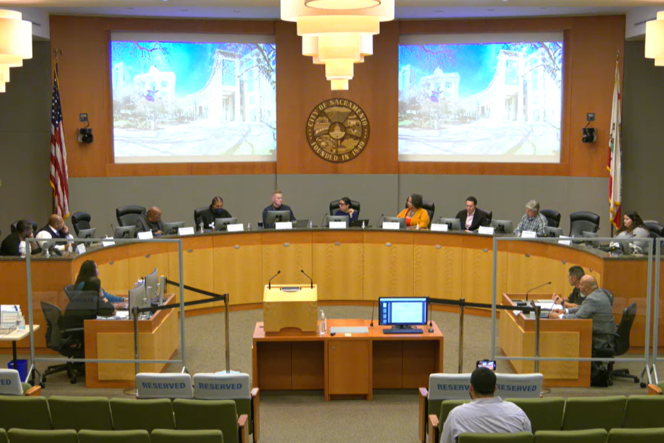 A group of commission members sitting at a long dais.