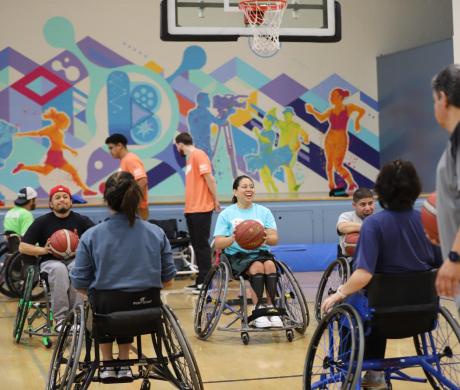 Individuals in wheelchairs play basketball