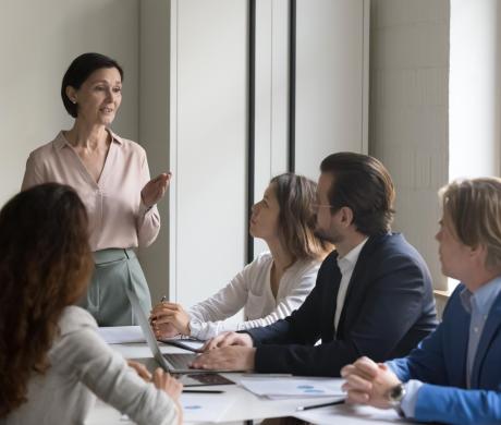 Woman speaking to team of professionals