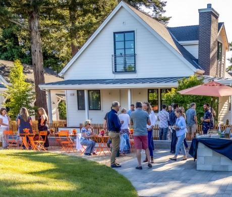 People socializing outside neighborhood cottages
