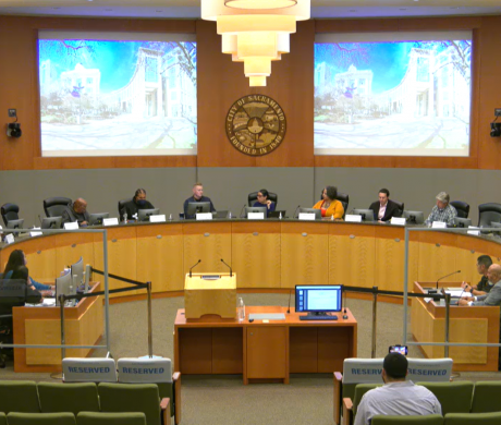 A group of commission members sitting at a long dais.