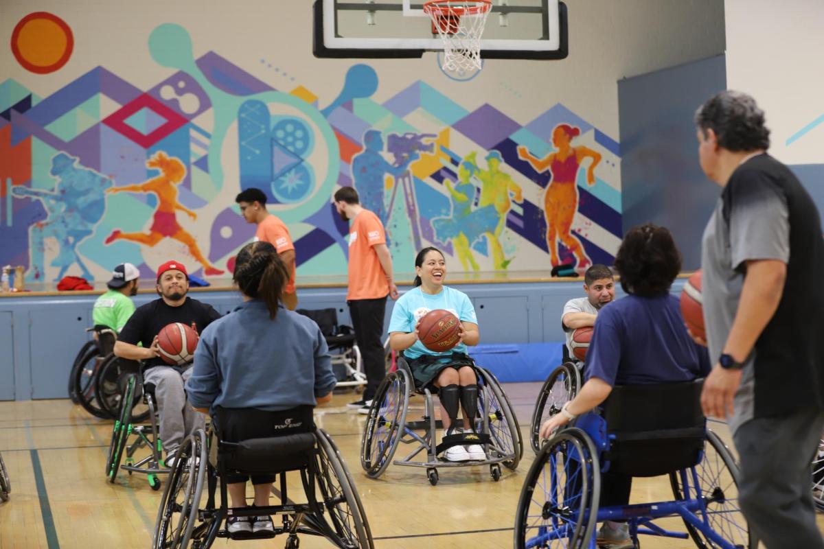 Individuals in wheelchairs play basketball
